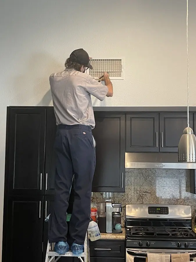 Technician inspecting an air vent during HVAC service in Hamlin